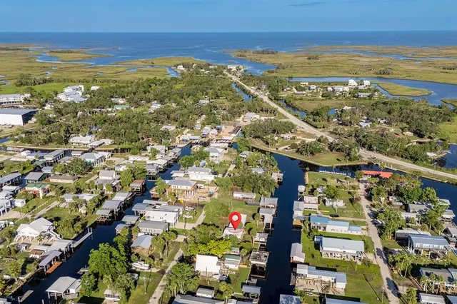 an aerial view of a residential houses with outdoor space and parking