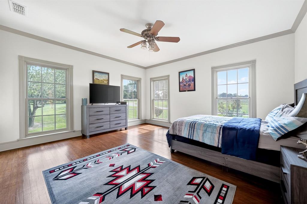 1901 Rose Pointe Athens, TX 75752 - Photo 22 of 37 Spacious room featuring wood-finish flooring, white walls with gray trim, multiple double-hung windows, and a ceiling fan with integrated lighting