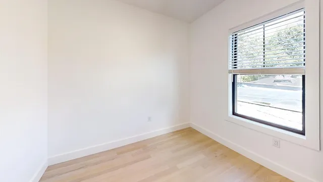 a view of an empty room with wooden floor