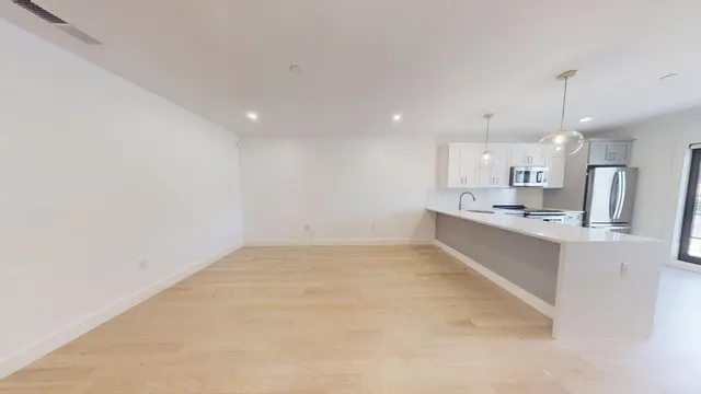a kitchen with kitchen island a sink and refrigerator