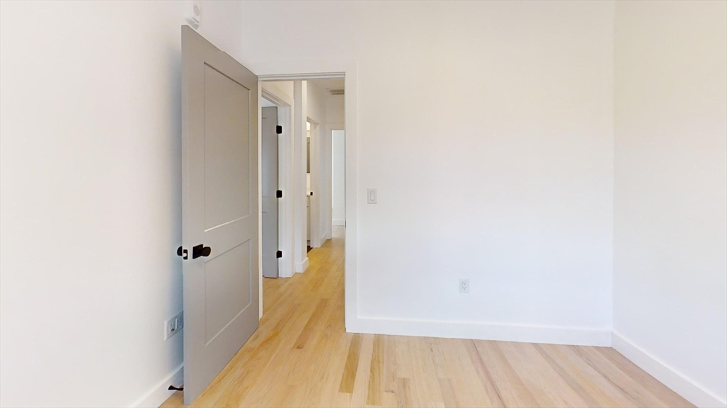 52 Withington Street, Unit 7 Boston, MA 02124 - Photo 9 of 19 a view of a hallway with wooden floor and a bathroom
