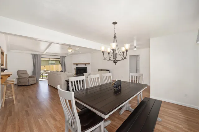 a view of a dining room with furniture a chandelier and wooden floor