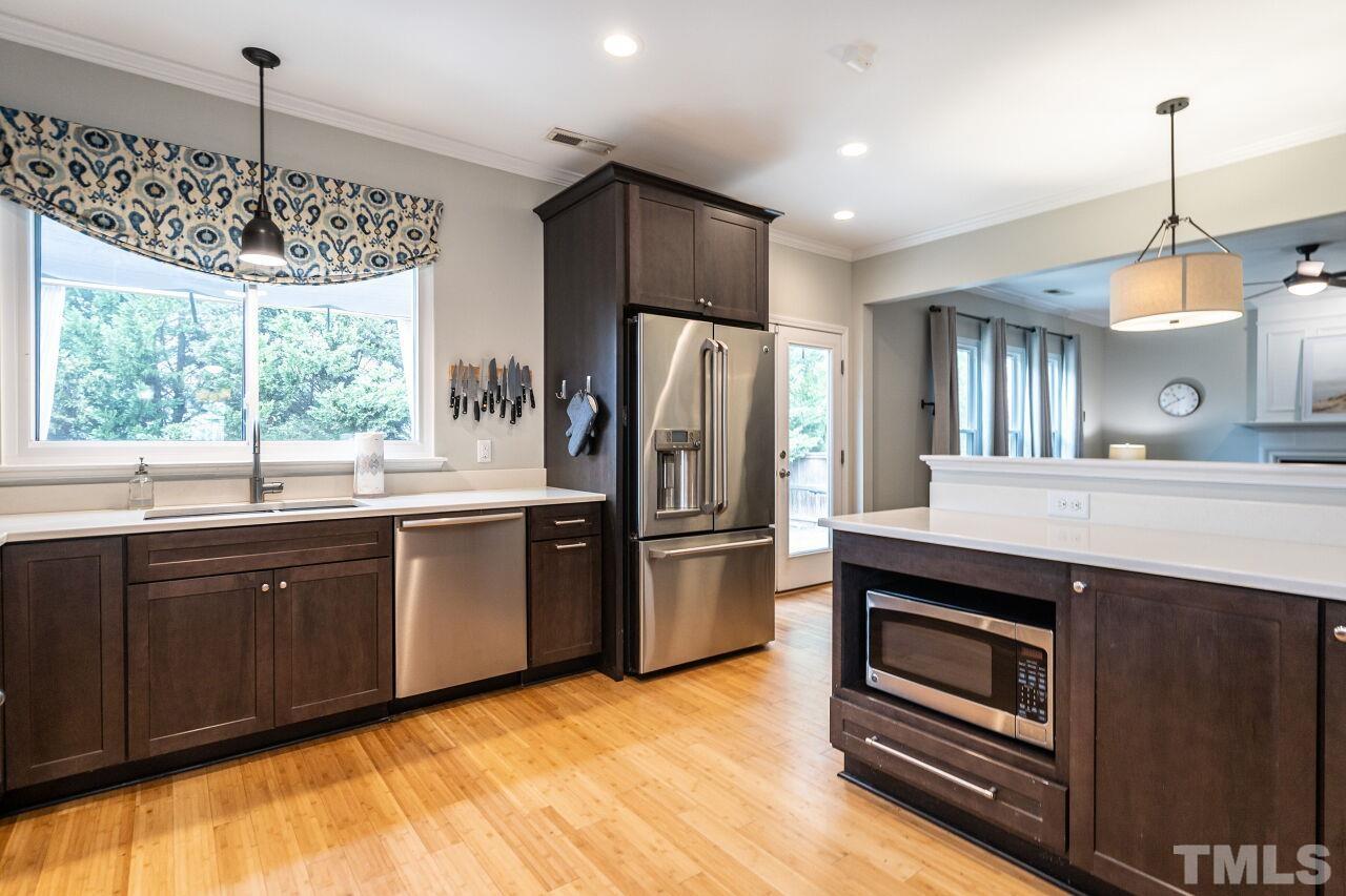 7443 Lagrange Drive Raleigh, NC 27613 - Photo 17 of 28 a kitchen with stainless steel appliances granite countertop a refrigerator a sink dishwasher a stove and white cabinets with wooden floor