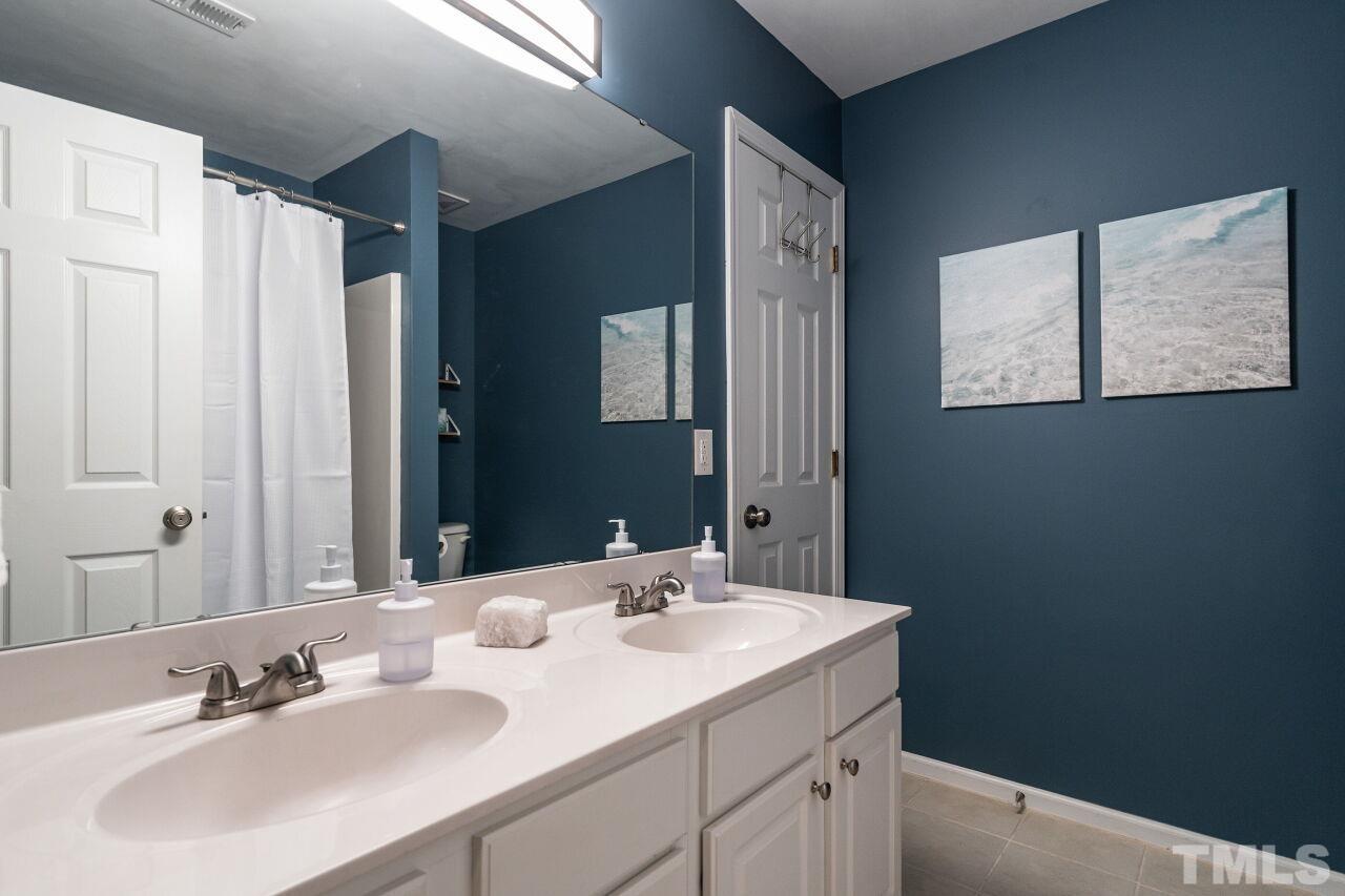 7443 Lagrange Drive Raleigh, NC 27613 - Photo 23 of 28 a bathroom with a sink and a mirror
