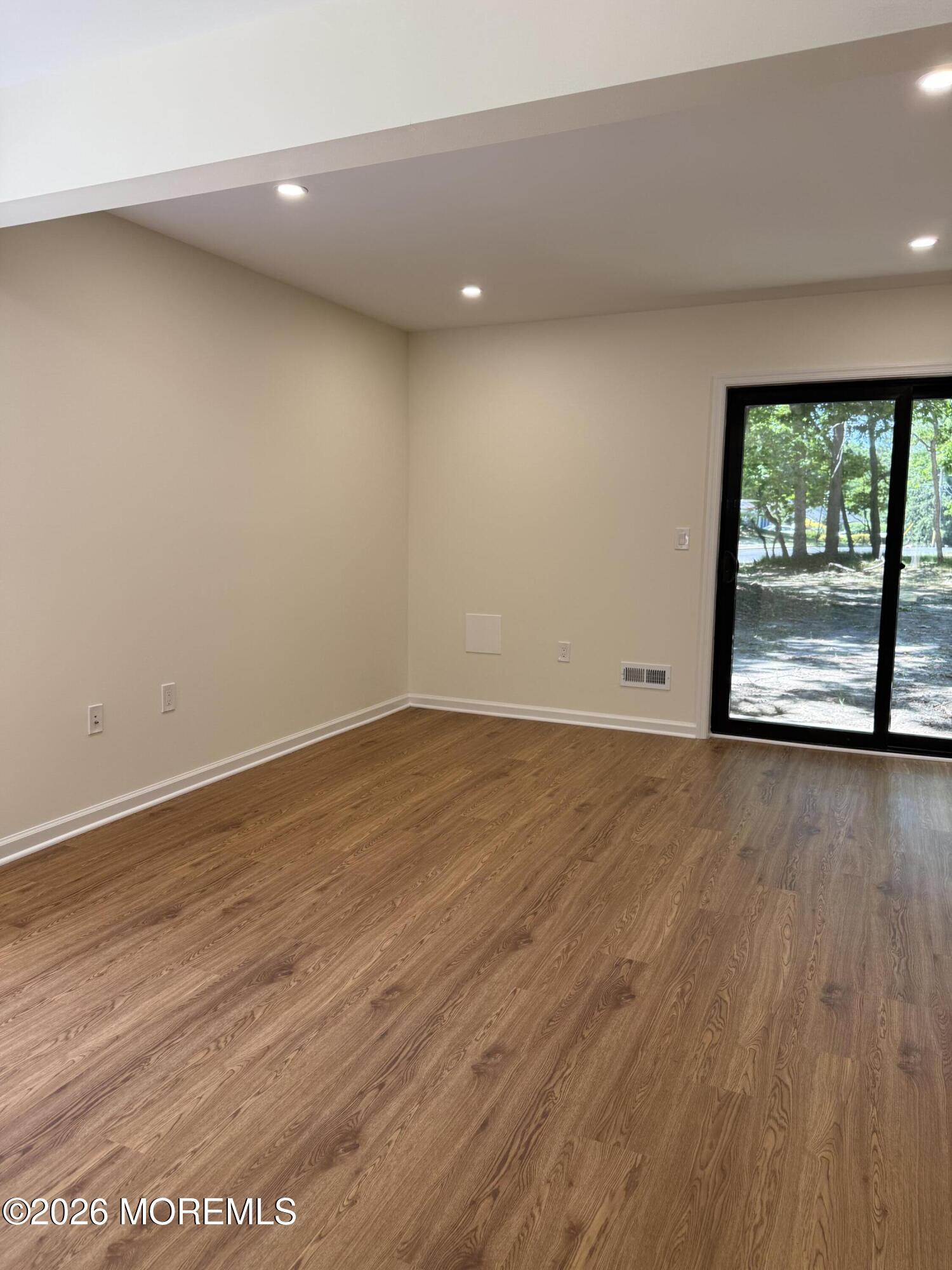 5 Canary Circle Howell, NJ 07731 - Photo 10 of 32 an empty room with wooden floor and windows