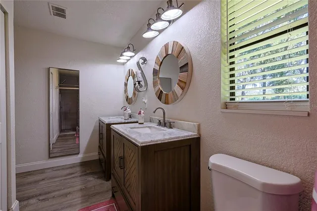 a bathroom with a toilet sink vanity and mirror
