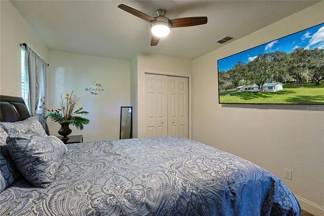 a bedroom with a bed and ceiling fan
