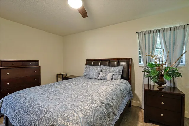 a bedroom with a large bed and a potted plant