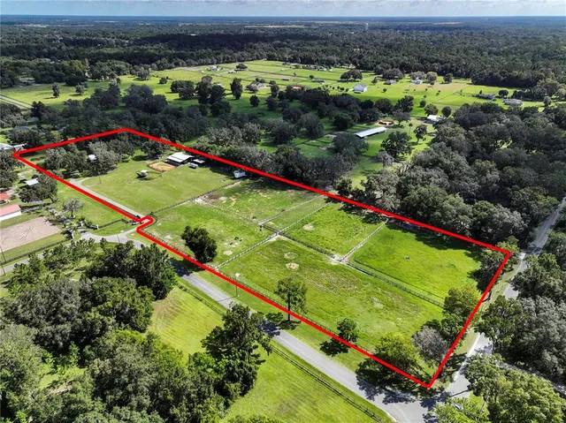an aerial view of residential houses with outdoor space and trees