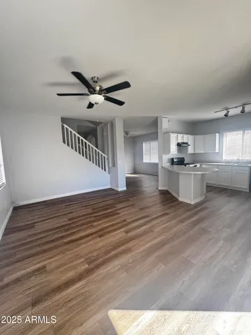 a view of a livingroom with kitchen and staircase
