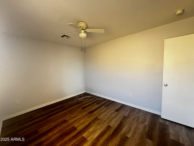 a view of a room with wooden floor and fan