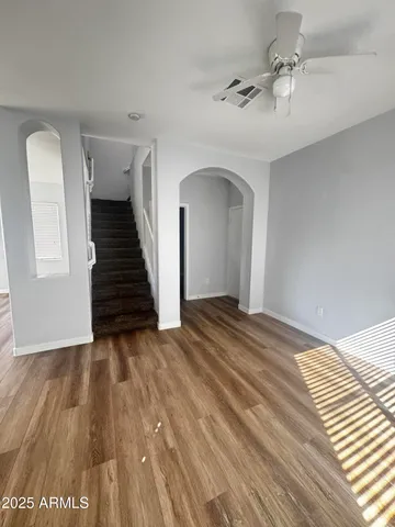 a view of a bedroom with wooden floor and ceiling fan