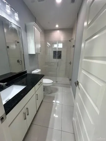 a bathroom with a granite countertop sink mirror and bathtub