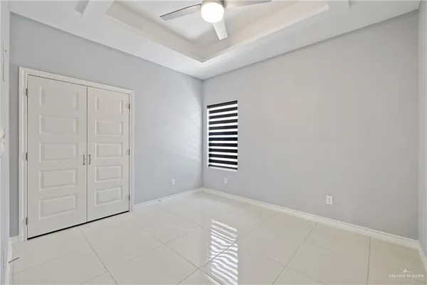 an empty room with windows and fan