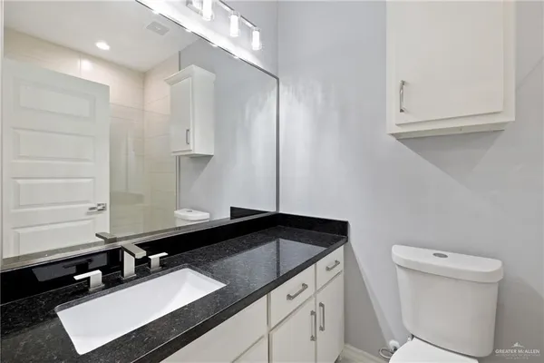 a bathroom with a sink a toilet and a mirror