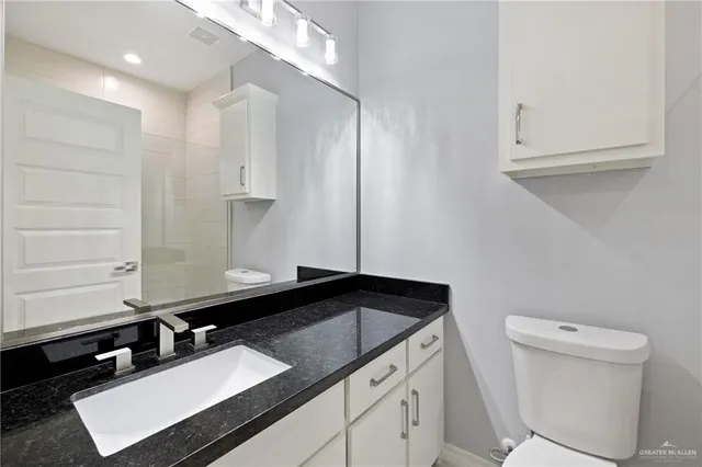 a bathroom with a sink a toilet and a mirror