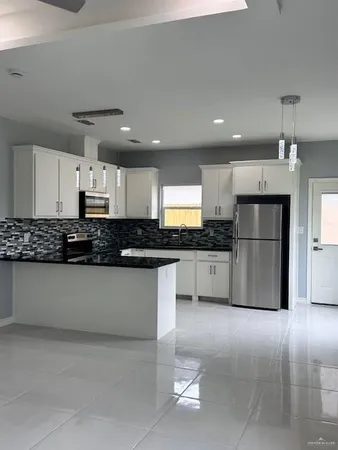 a kitchen with stainless steel appliances granite countertop a refrigerator and a stove