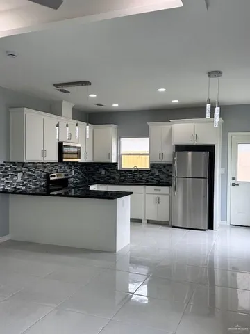 a kitchen with stainless steel appliances granite countertop a refrigerator and a stove