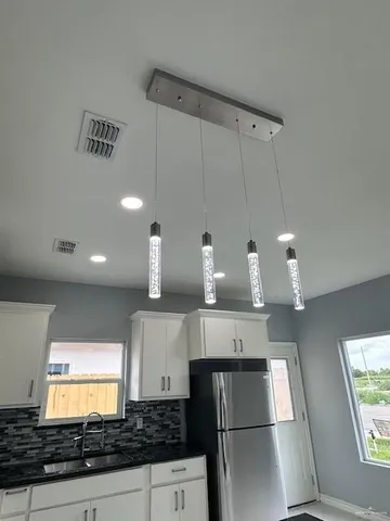 a kitchen with kitchen island granite countertop a sink cabinets and stainless steel appliances