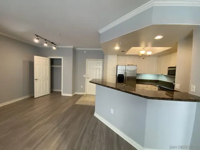 a large kitchen with stainless steel appliances a large counter top a refrigerator and a sink