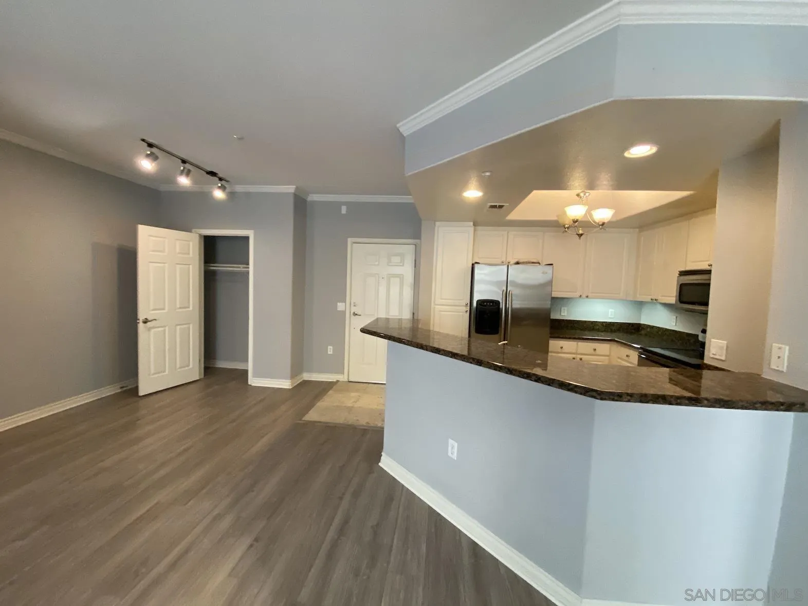 a large kitchen with stainless steel appliances a large counter top a refrigerator and a sink