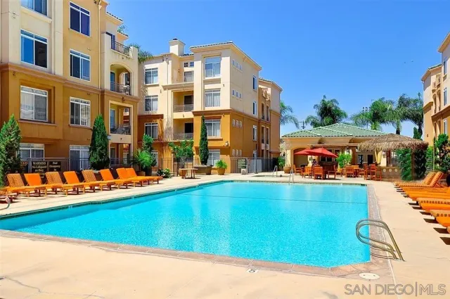a view of a swimming pool with lawn chairs and plants