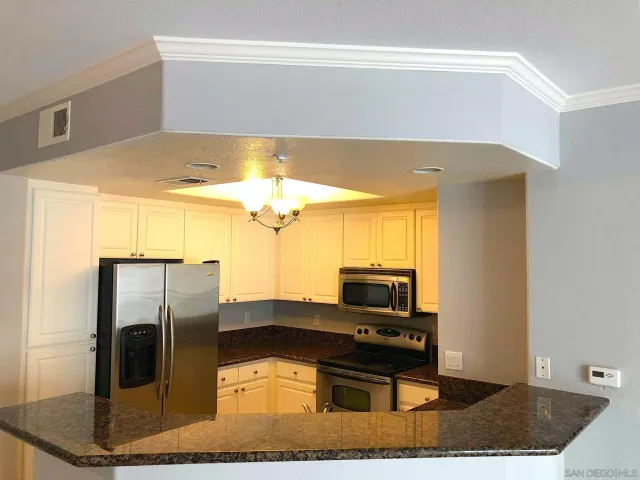 a kitchen with stainless steel appliances granite countertop a refrigerator and a stove