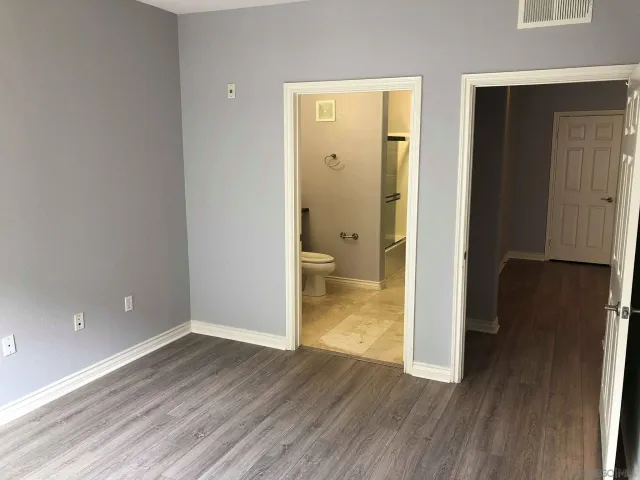a view of a room with wooden floor and a bathroom