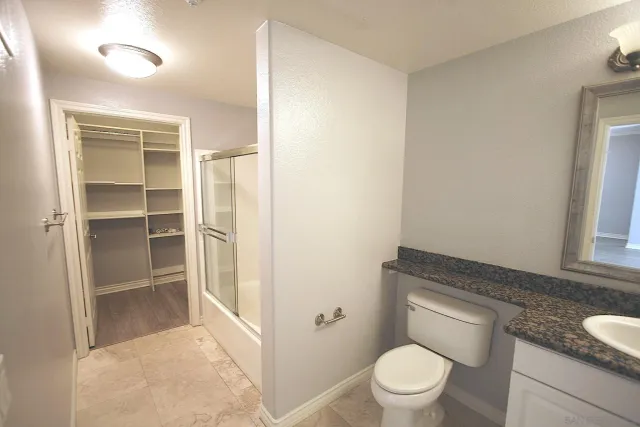 a bathroom with a granite countertop toilet and a sink
