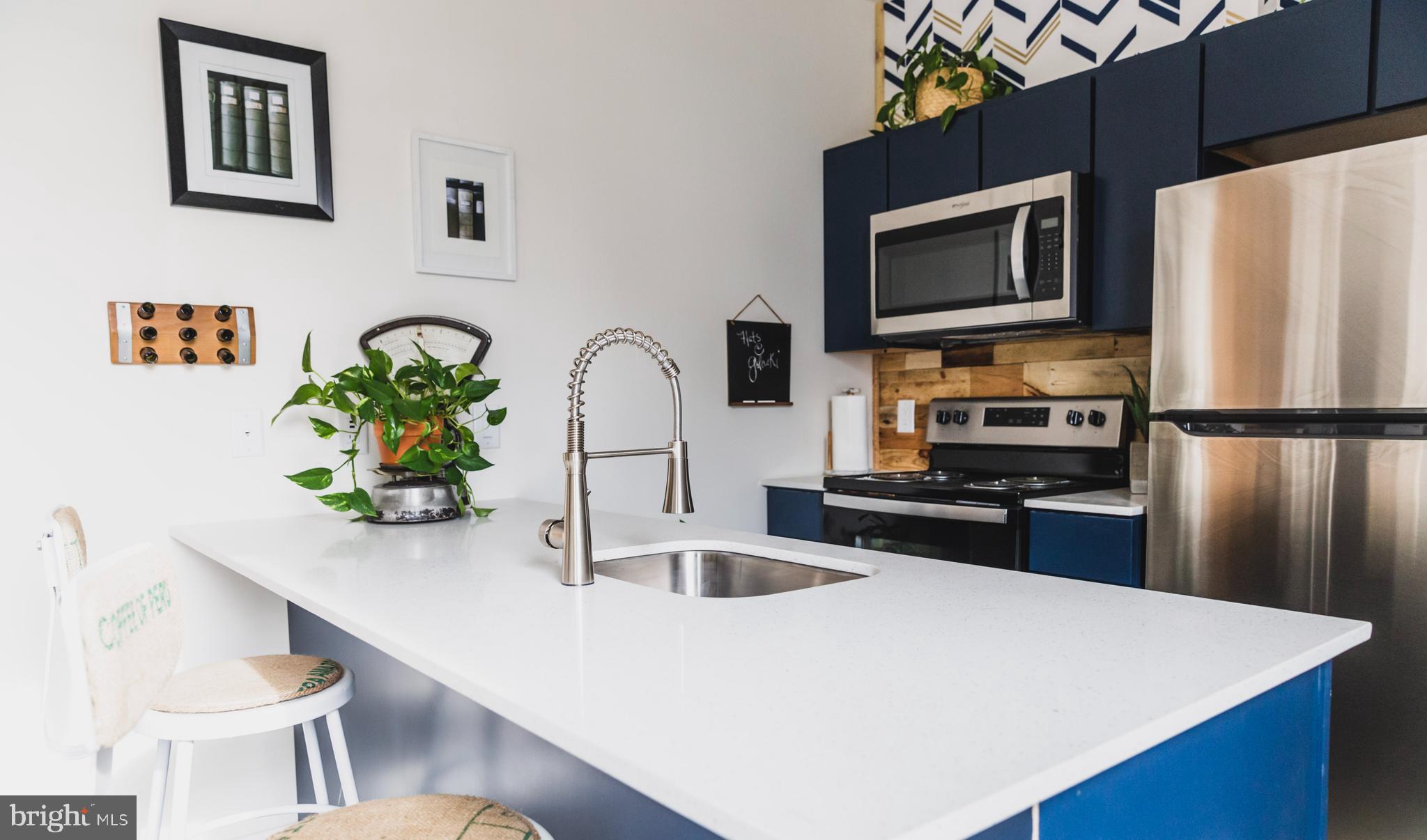 4537 Wayne Avenue, Unit B Philadelphia, PA 19144 - Photo 6 of 16 a kitchen with stainless steel appliances a stove a microwave a sink a refrigerator and white cabinets