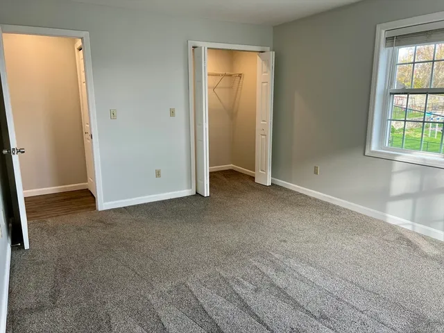an empty room with windows and closet