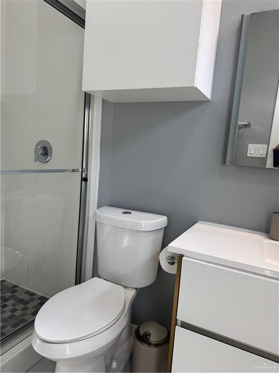2022 Summerland Lane, Unit 4 Edinburg, TX 78541 - Photo 11 of 31 a white toilet sitting next to a bathroom sink and vanity