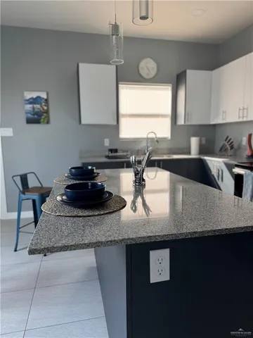 a kitchen with granite countertop a sink a stove and cabinets