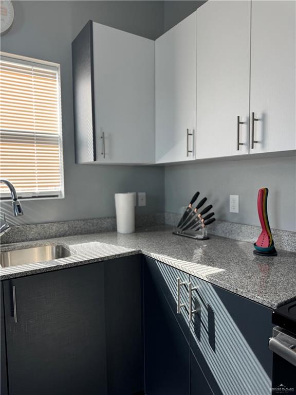 2022 Summerland Lane, Unit 4 Edinburg, TX 78541 - Photo 7 of 31 a kitchen with granite countertop a sink a stove and cabinets
