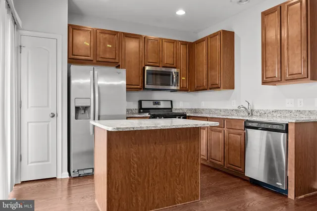 a kitchen with granite countertop stainless steel appliances a refrigerator and a sink