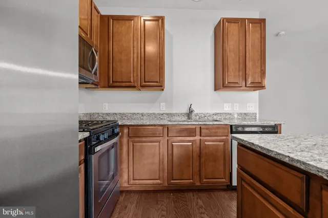 a kitchen with granite countertop cabinets stainless steel appliances and a counter space