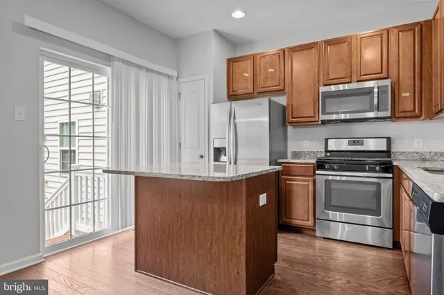 a kitchen with stainless steel appliances granite countertop a refrigerator microwave and sink