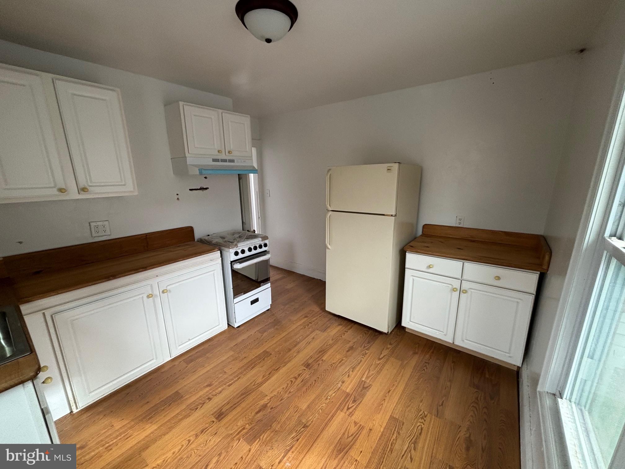 26 Walnut Street Bridgeton, NJ 08302 - Photo 3 of 22 a kitchen with a refrigerator and white cabinets