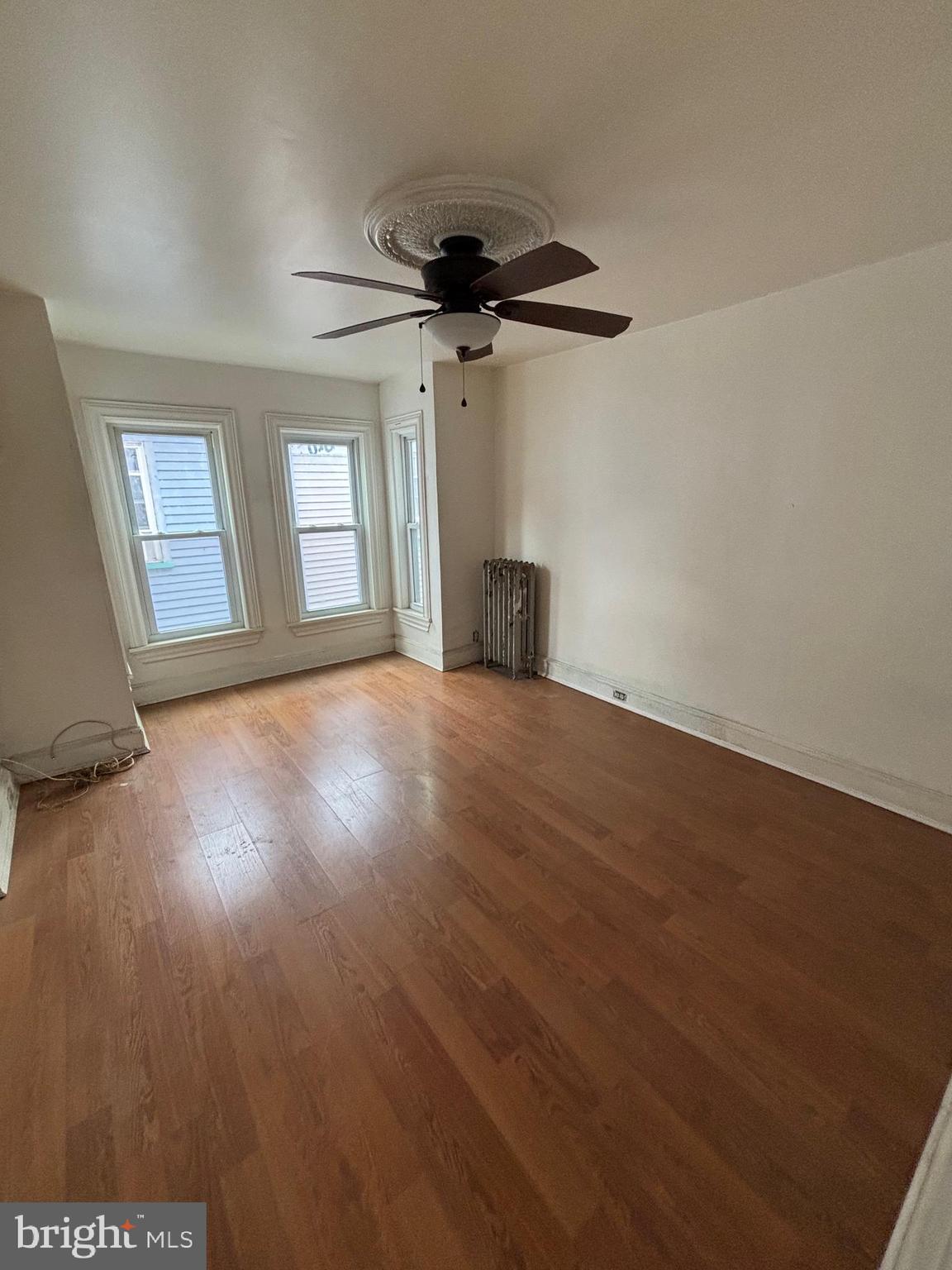 26 Walnut Street Bridgeton, NJ 08302 - Photo 4 of 22 en empty room with windows and ceiling fan