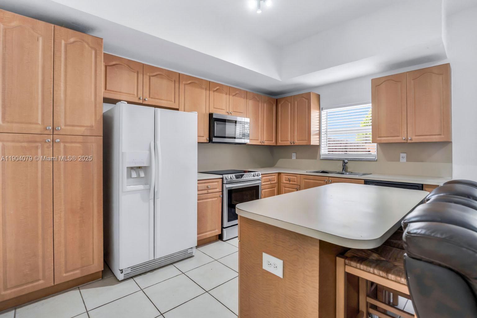 22232 Southwest 88th Path Cutler Bay, FL 33190 - Photo 14 of 72 a kitchen with stainless steel appliances granite countertop a refrigerator a sink a stove a washer dryer and a cabinets