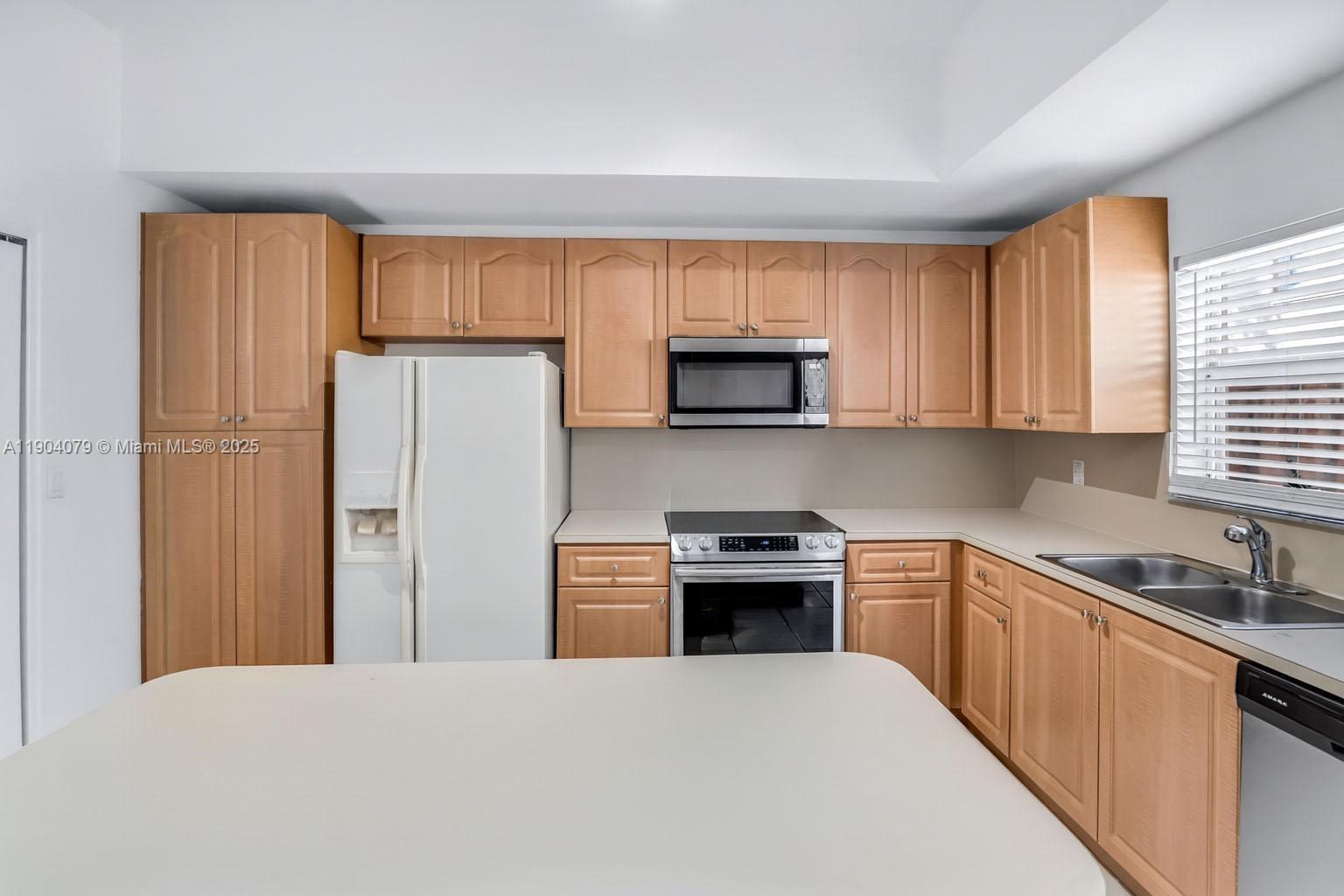 22232 Southwest 88th Path Cutler Bay, FL 33190 - Photo 16 of 72 a kitchen with stainless steel appliances granite countertop a refrigerator stove and sink