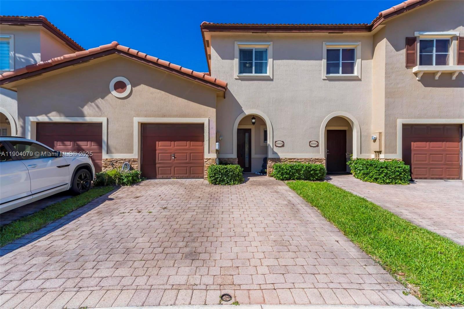 22232 Southwest 88th Path Cutler Bay, FL 33190 - Photo 2 of 72 a front view of a house with a yard and garage