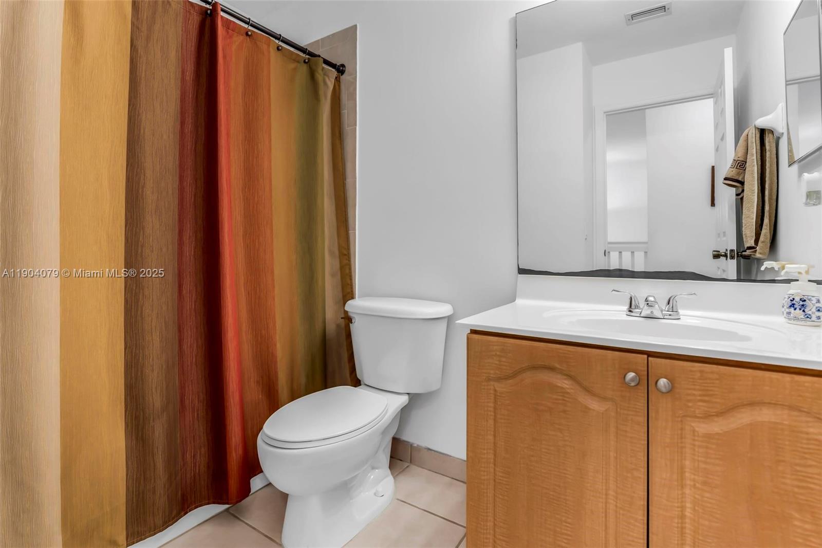 22232 Southwest 88th Path Cutler Bay, FL 33190 - Photo 27 of 72 a bathroom with a granite countertop toilet sink and mirror