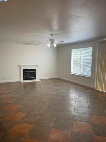 an empty room with windows and fireplace