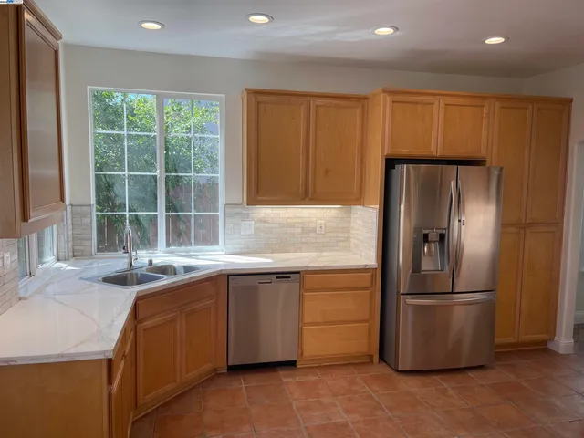 a kitchen with stainless steel appliances granite countertop a refrigerator and a sink