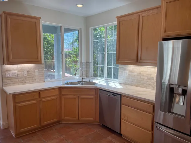 a kitchen with a sink window and refrigerator