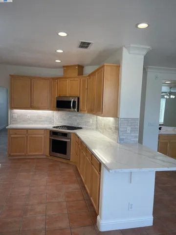 a kitchen with stainless steel appliances granite countertop a sink and a stove