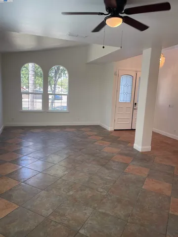 an empty room with windows and fan