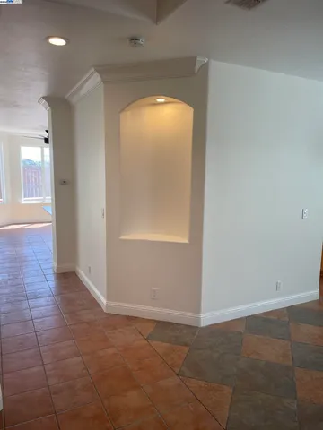 an empty room with a bathroom and windows