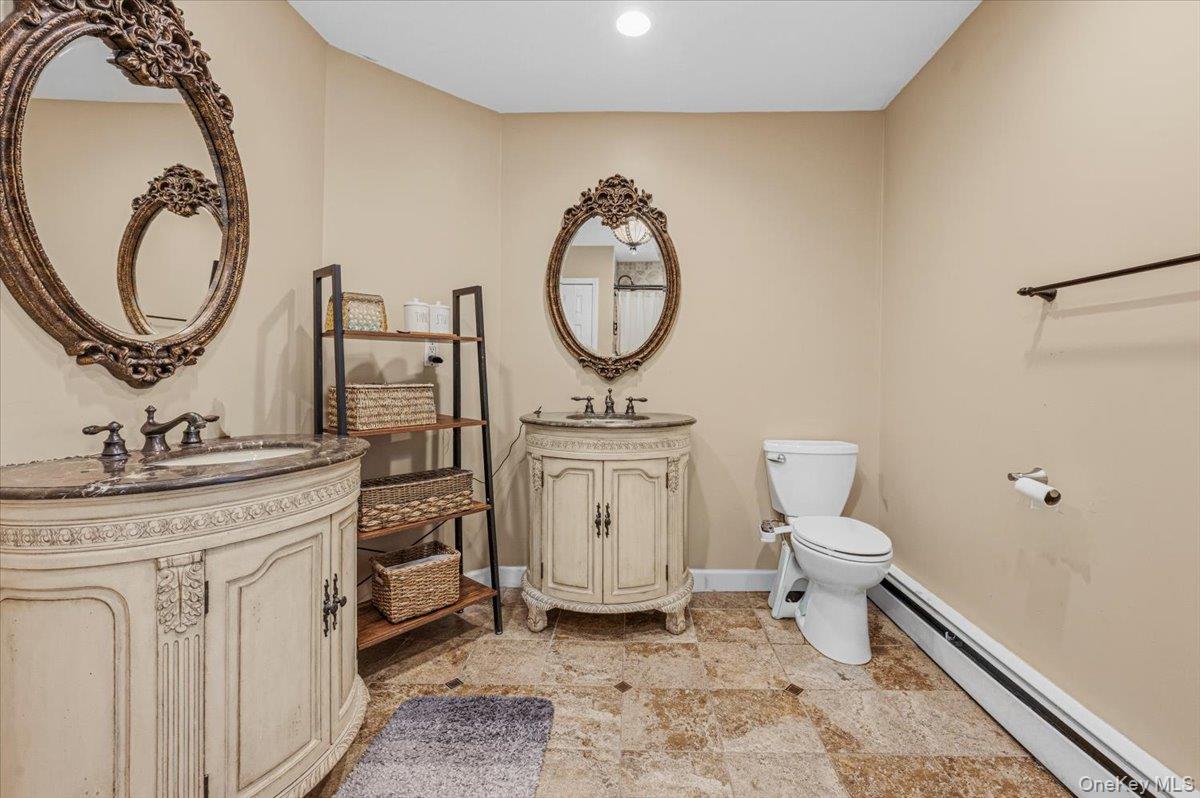 626 Caledonia Road Dix Hills, NY 11746 - Photo 26 of 49 a bathroom with a toilet a sink and a mirror